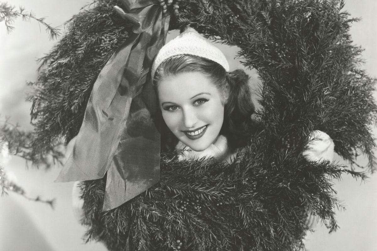 vintage black and white photo of woman holding a christmas wreath