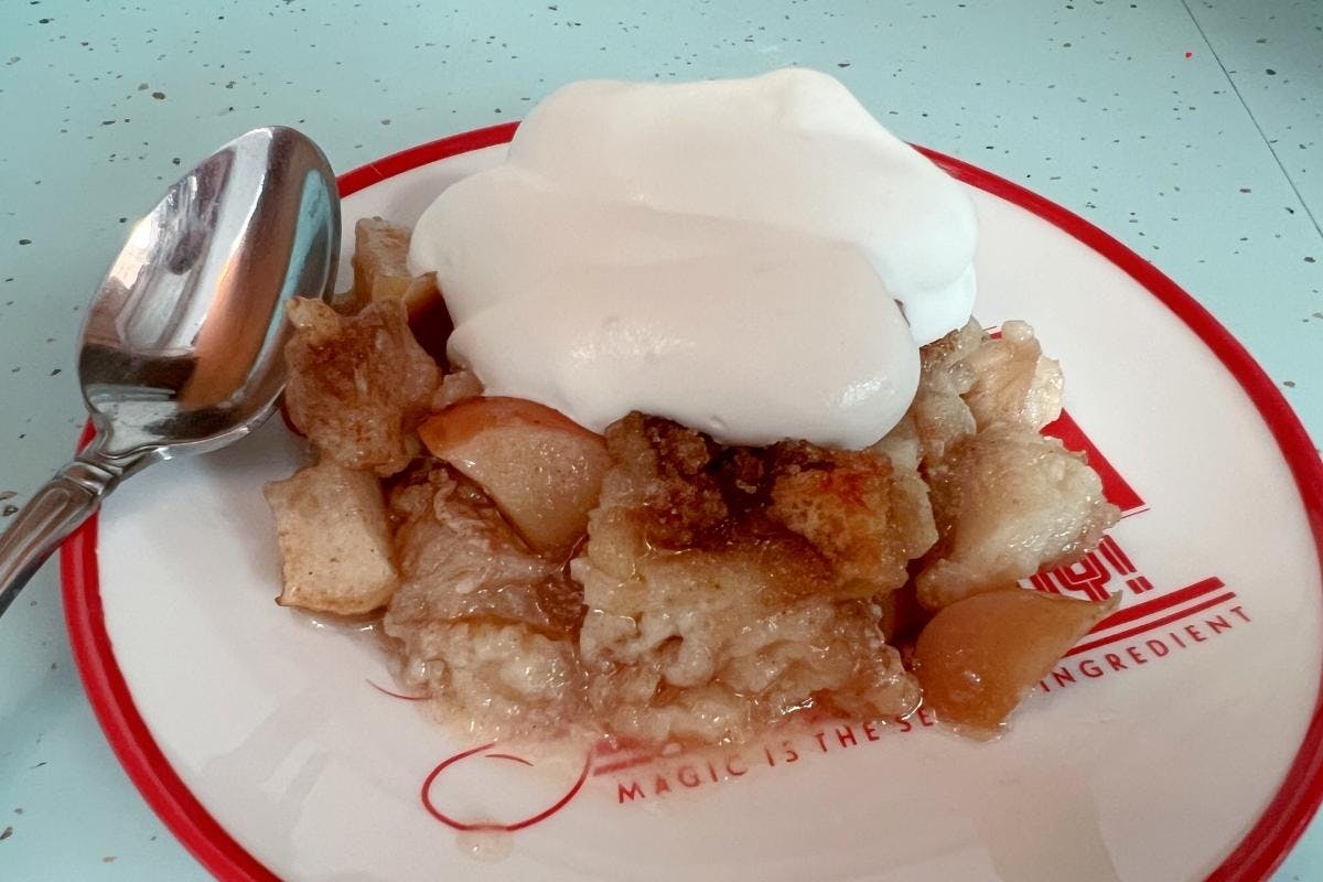 Apple bread pudding on a plate with whipped cream