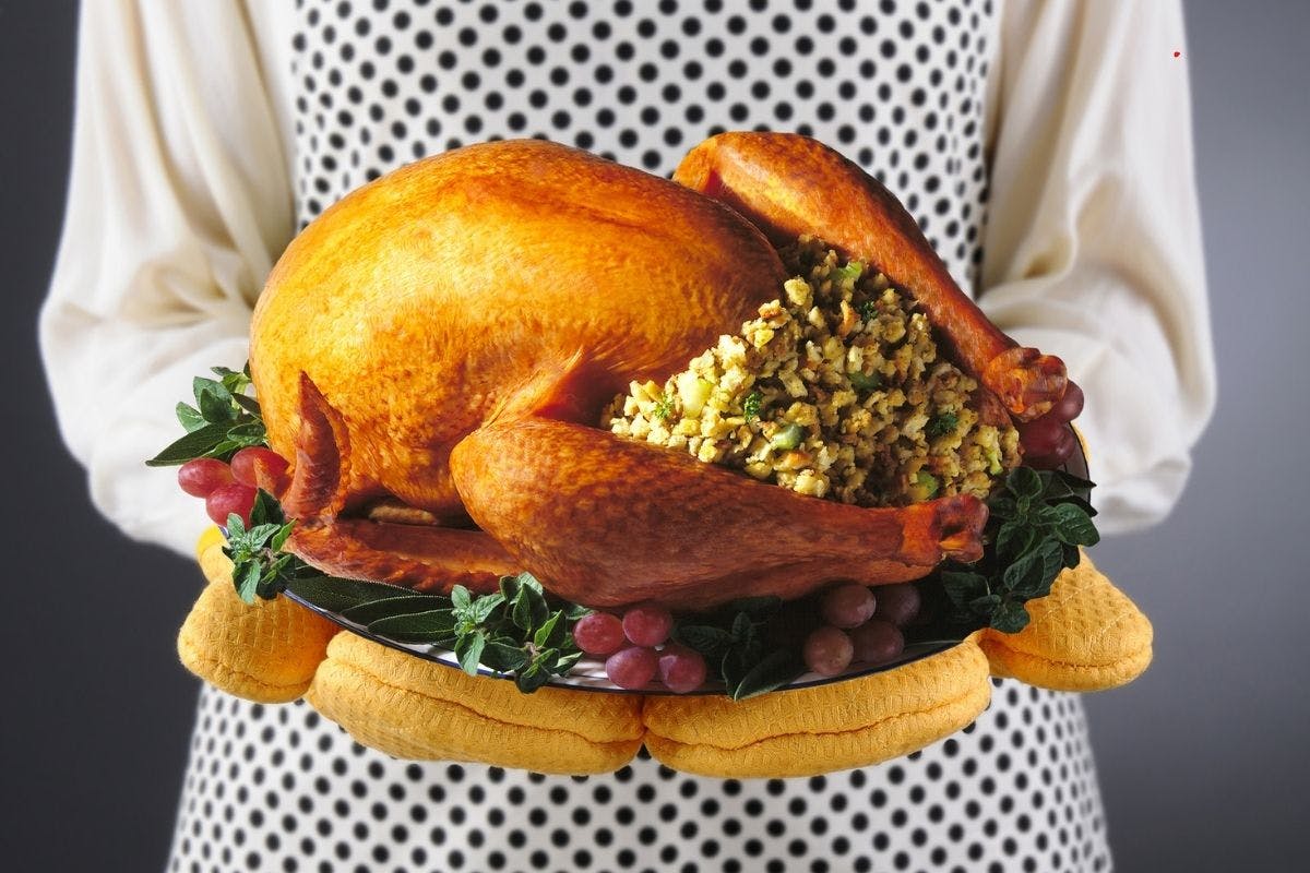 woman holding a turkey on platter