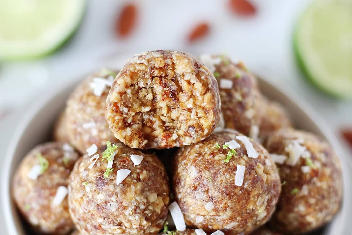 A bowl full of lime coconut energy balls.