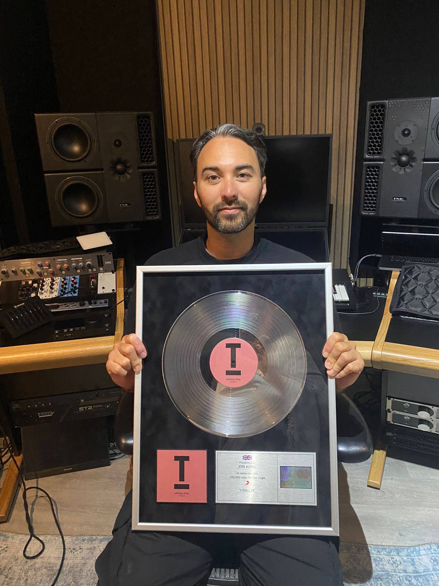 Jon Kong holding a certified silver disc