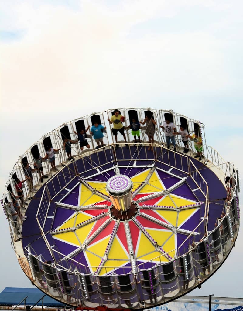 People enjoy a spinning amusement park ride.