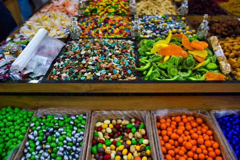 Colorful assorted candies and nuts displayed at market.