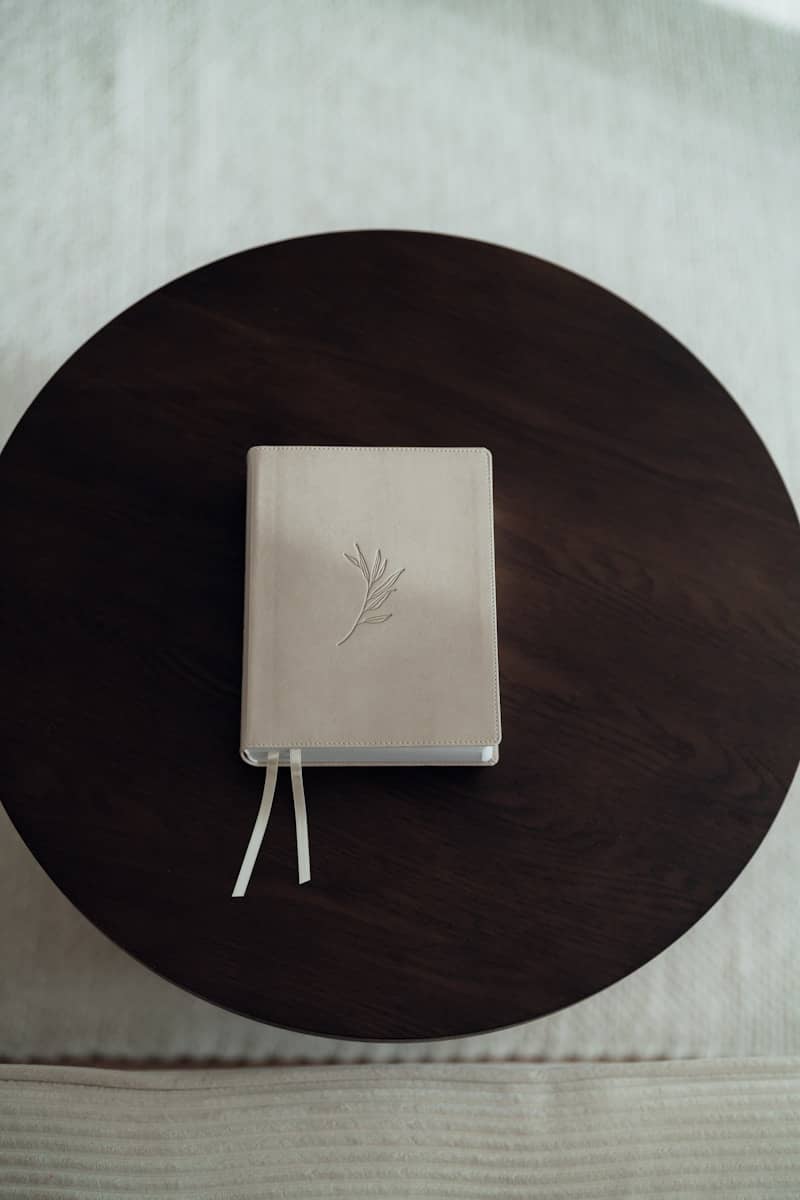 A closed white journal with a twig embossed on cover.