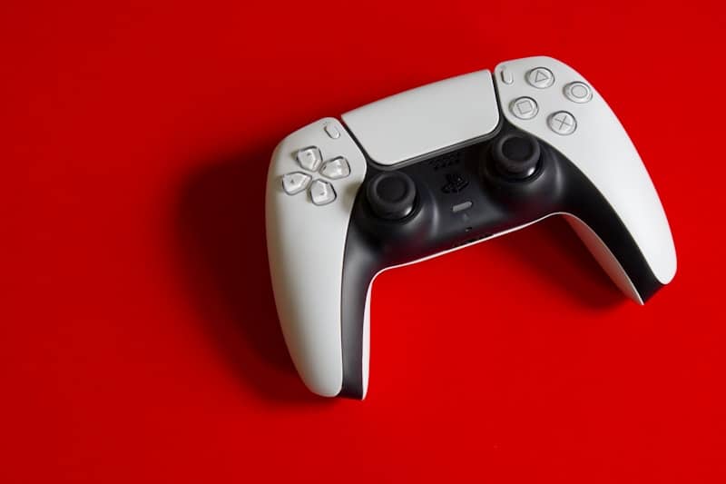 Playstation 5 dualsense controller on a red surface.