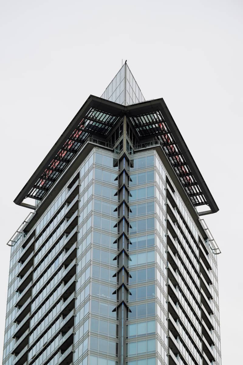 Modern glass skyscraper with a unique angular roof.