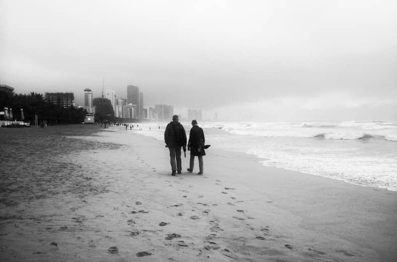 A man and a woman walking on a beach