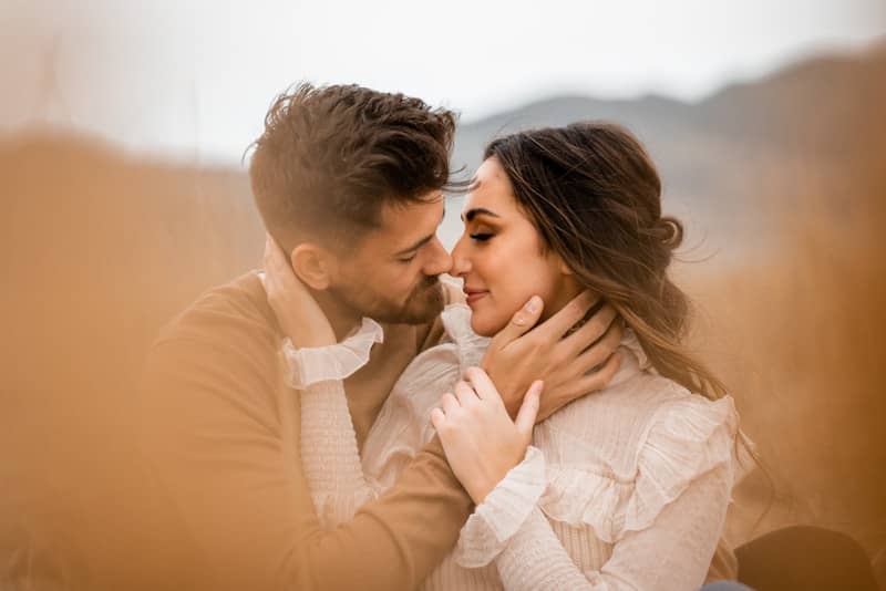 A man and a woman embracing in a field