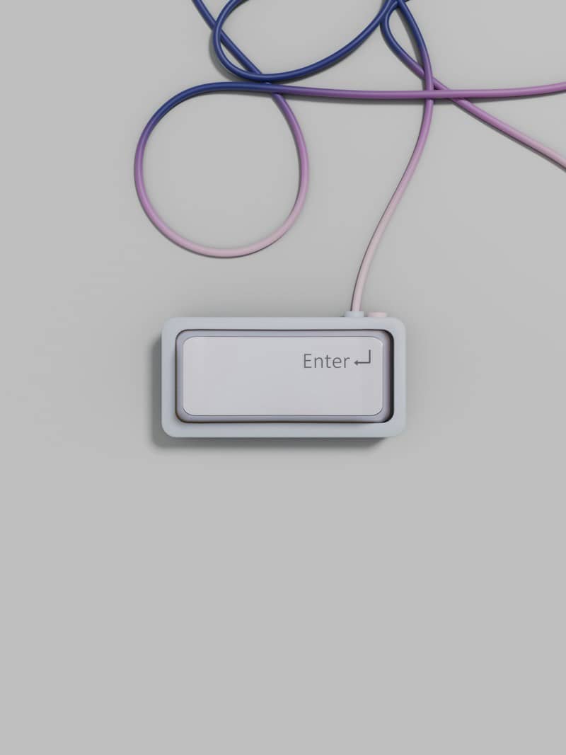 A single enter key with a gradient cable on a grey surface