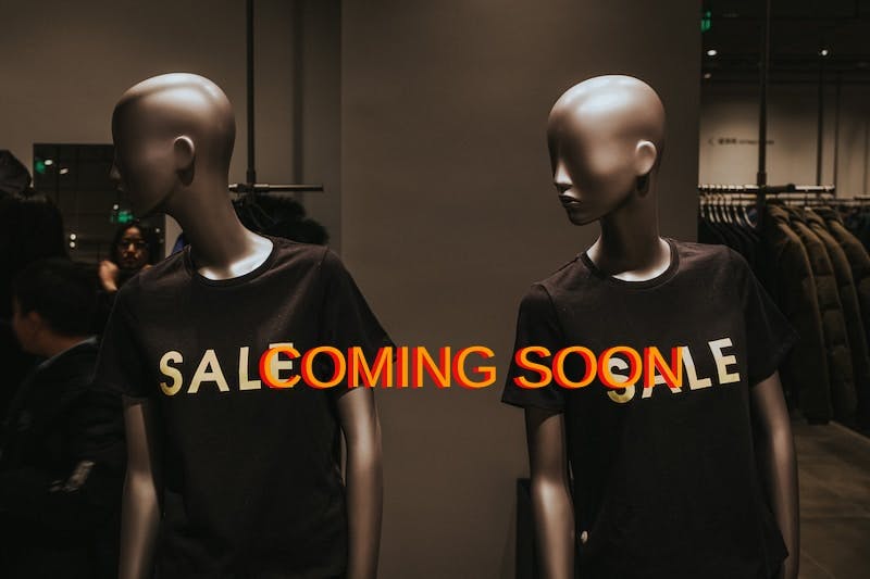 two mannequins with black Sale graphic crew-neck t-shirts