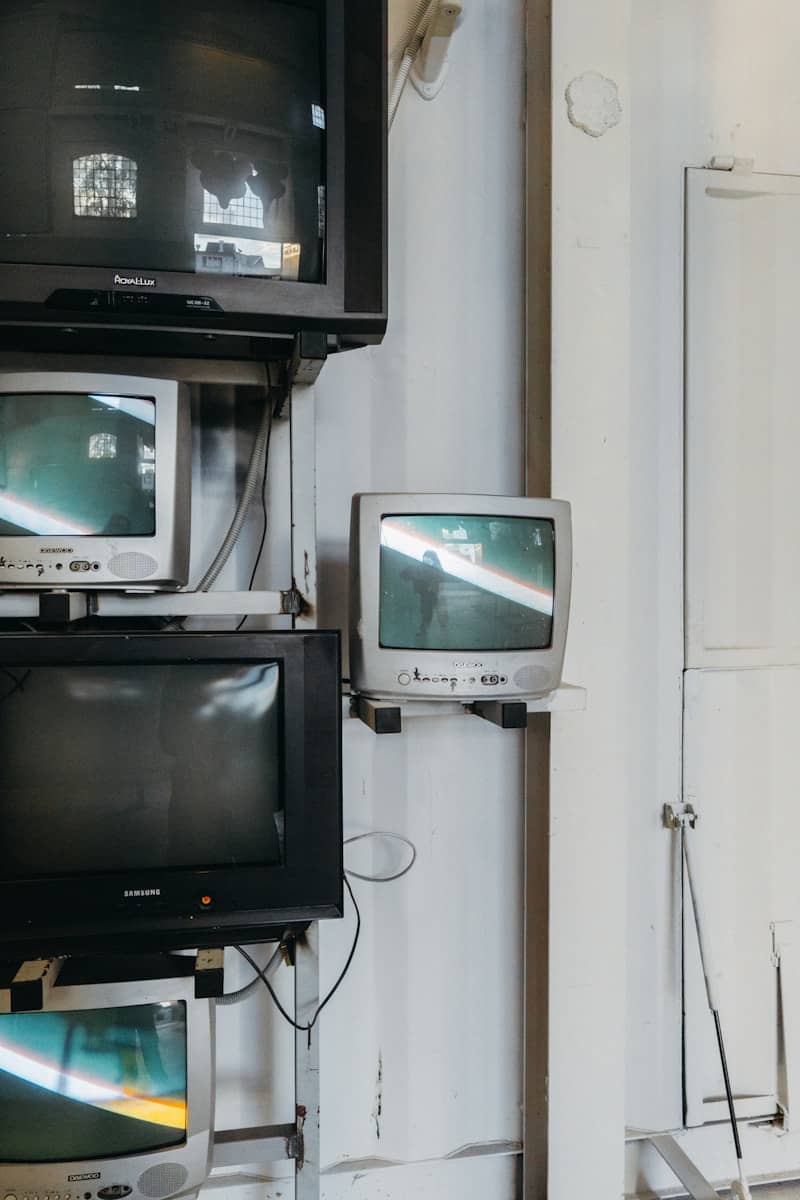 Stack of old televisions on a white wall