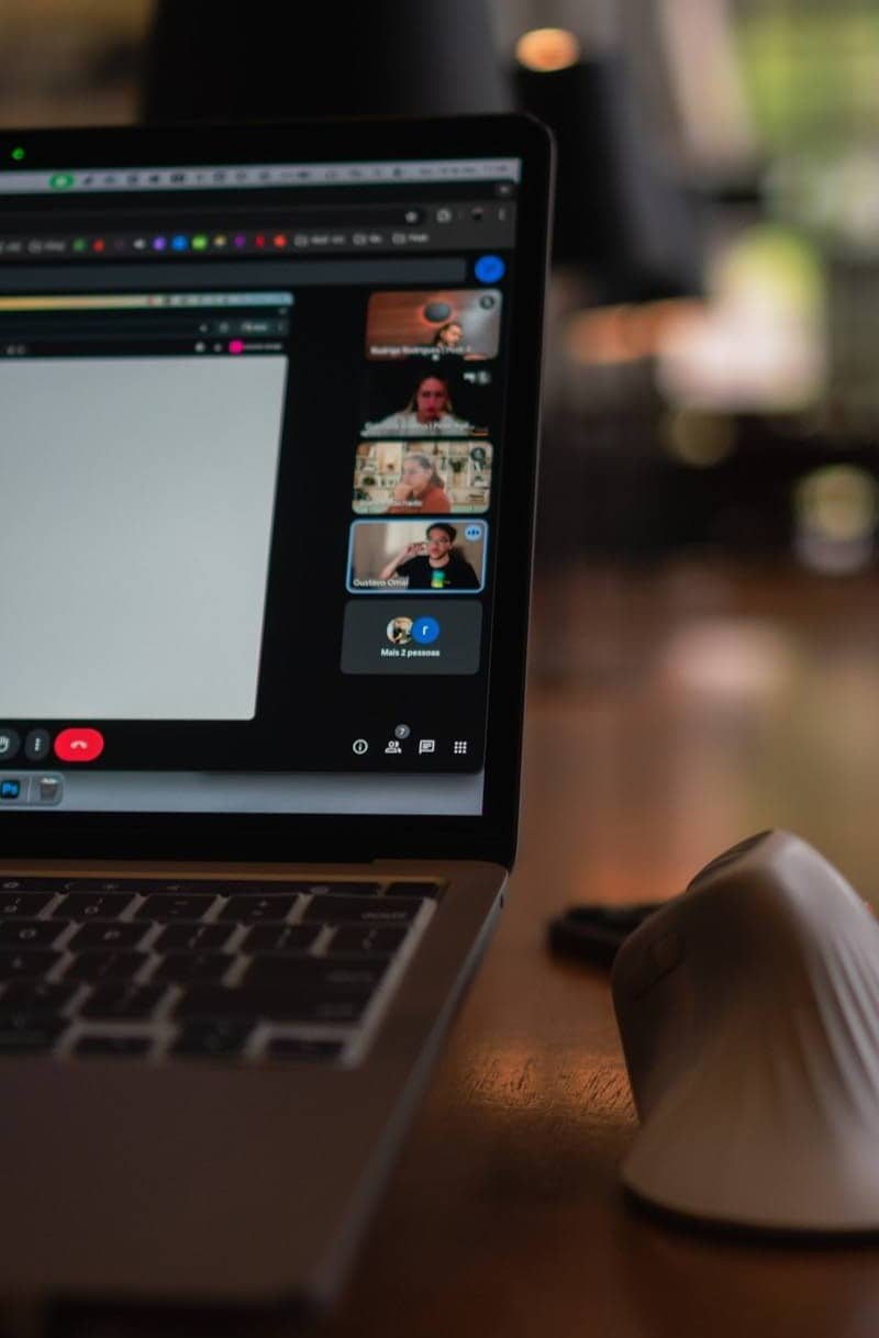 Laptop screen showing a video conference with multiple participants.