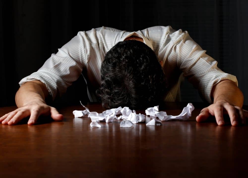 frustated person with head on desk - representing our frustration with our chicken processor messing up our pastured poultry order
