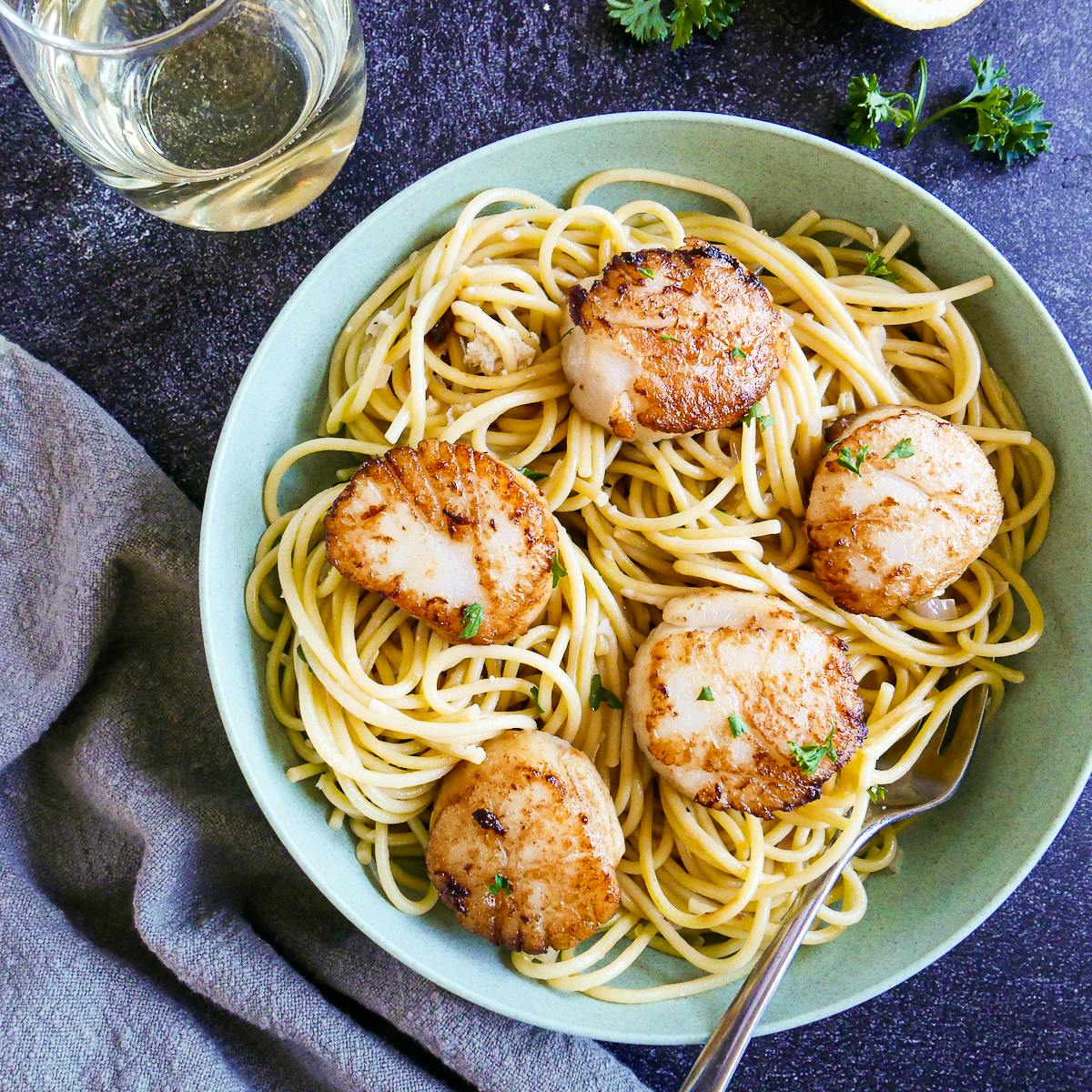 creamy scallop linguine plated in a bowl with a fork.