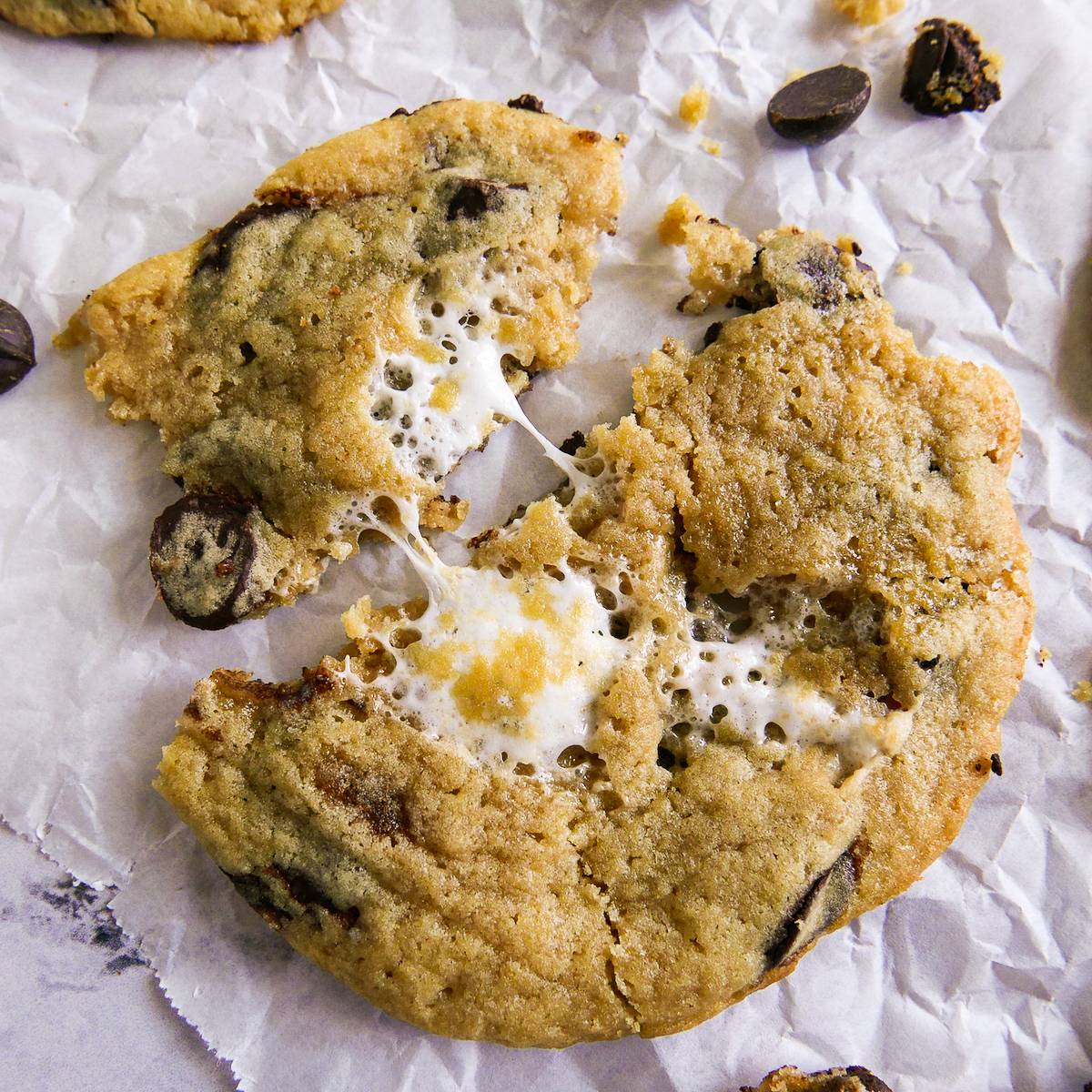 Chocolate chip marshmallow cookie resting on parchment paper.