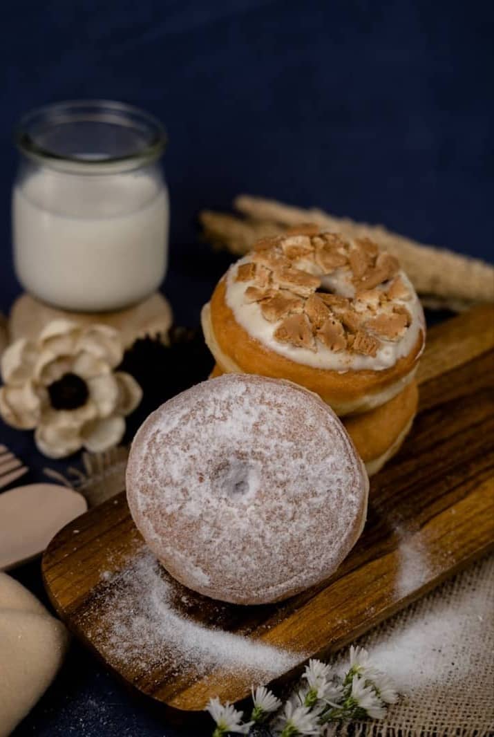 Delicious donuts and a glass of milk are pictured.