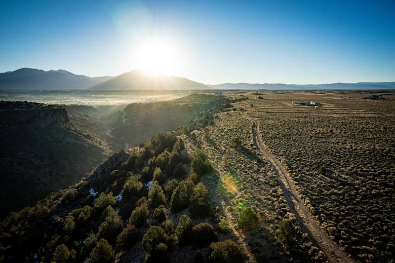Sun shines over a rugged landscape.