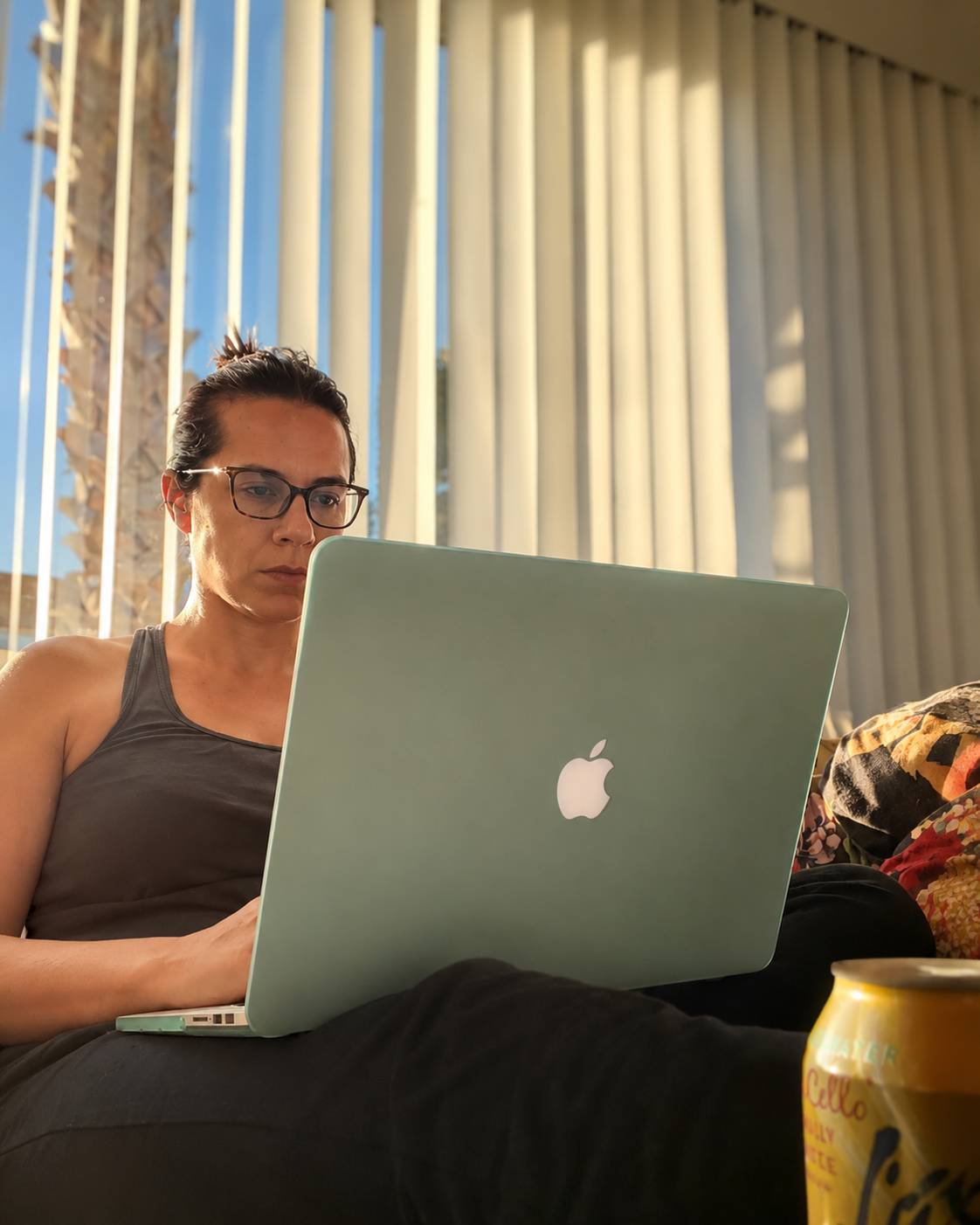 Woman working on a computer on a sunlight day in front of a window