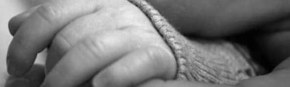 a black and white photo of a person holding a baby