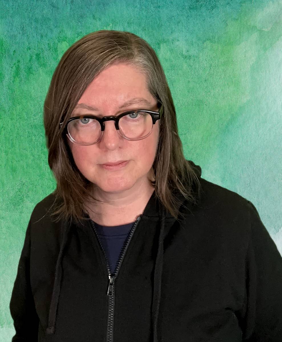 headshot of jen dehaan wearing glasses and black hoodie