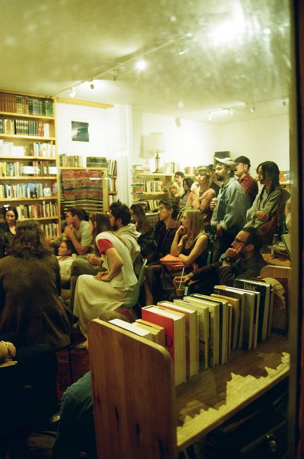 Attendees of Sunstroke Press' first anniversary reading at Reverie Bookstand listen intently.