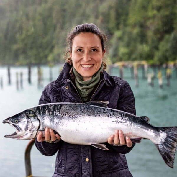 Aysegul holding a salmon in her hand.