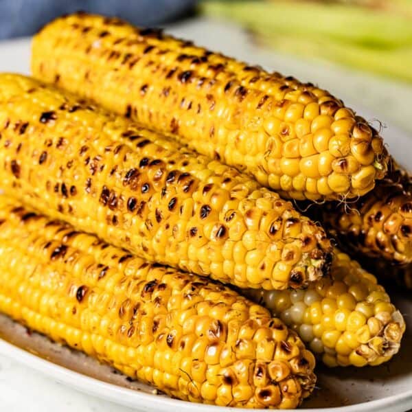 Five pieces of grilled corn on the cob on a plate