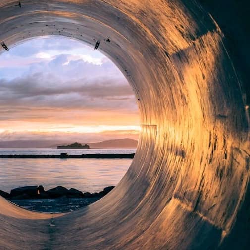 body of water can be seen through the tunnel