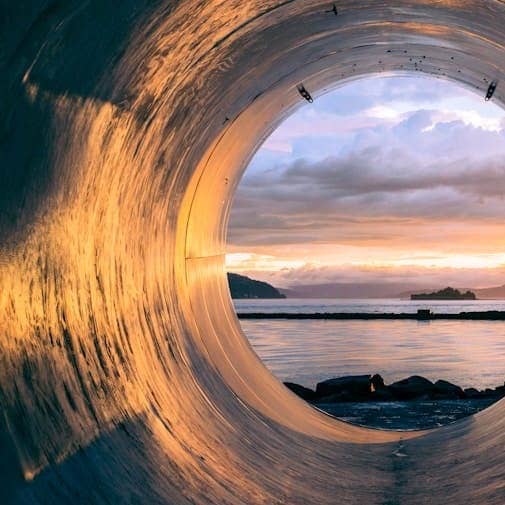 body of water can be seen through the tunnel