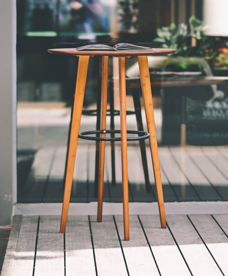 A tall wooden table with a book on top.