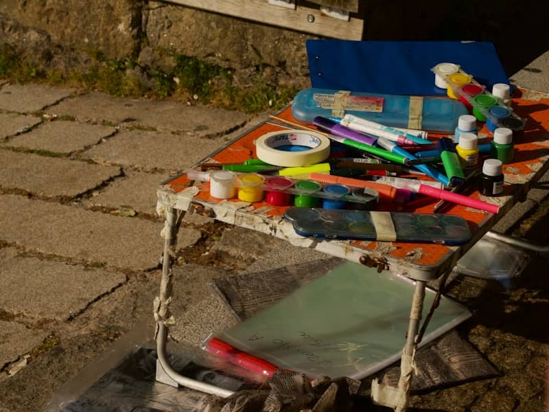 Art supplies like paints and markers on a small table.