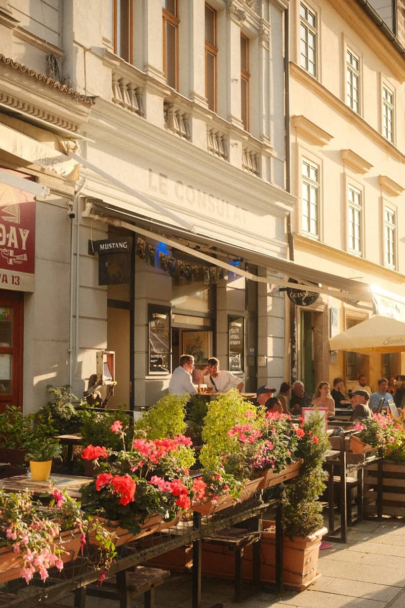 People are enjoying a meal at a restaurant's outdoor seating.