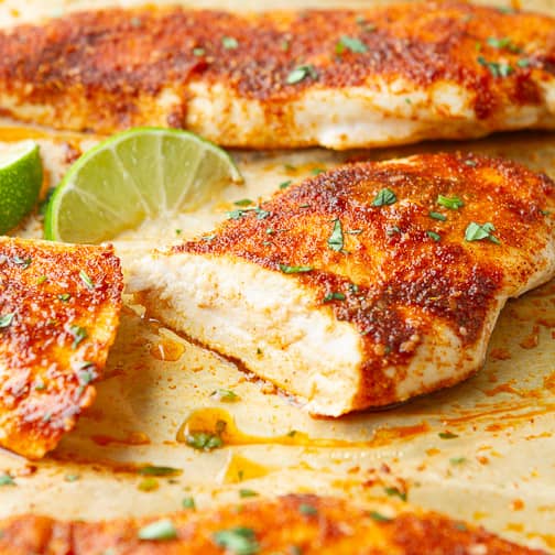 Cooked spice-rubbed chicken breast on parchment paper.