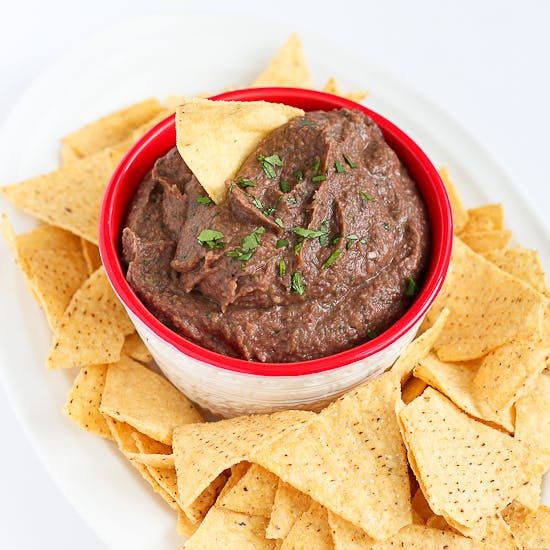 Black bean dip in a bowl, surrounded by tortilla chips.