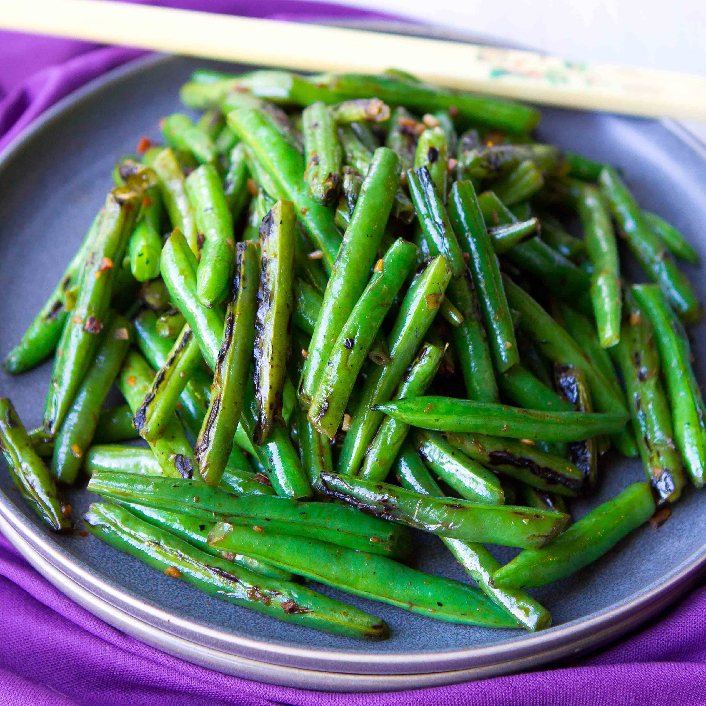 Stir-fried green beans piled on a plate.