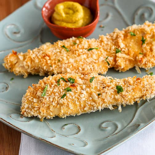 Baked breaded chicken strips on a plate.