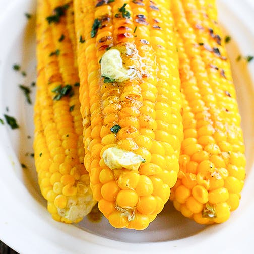 Corn cobs topped with butter and spices.