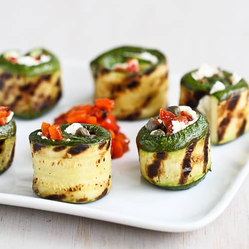 Grilled zucchini rolls stuffed with cheese and chopped peppers.
