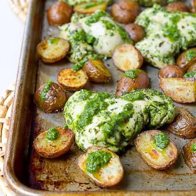 Roasted chicken and potatoes on a baking sheet.