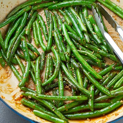 Glazed green beans in a large skillet.