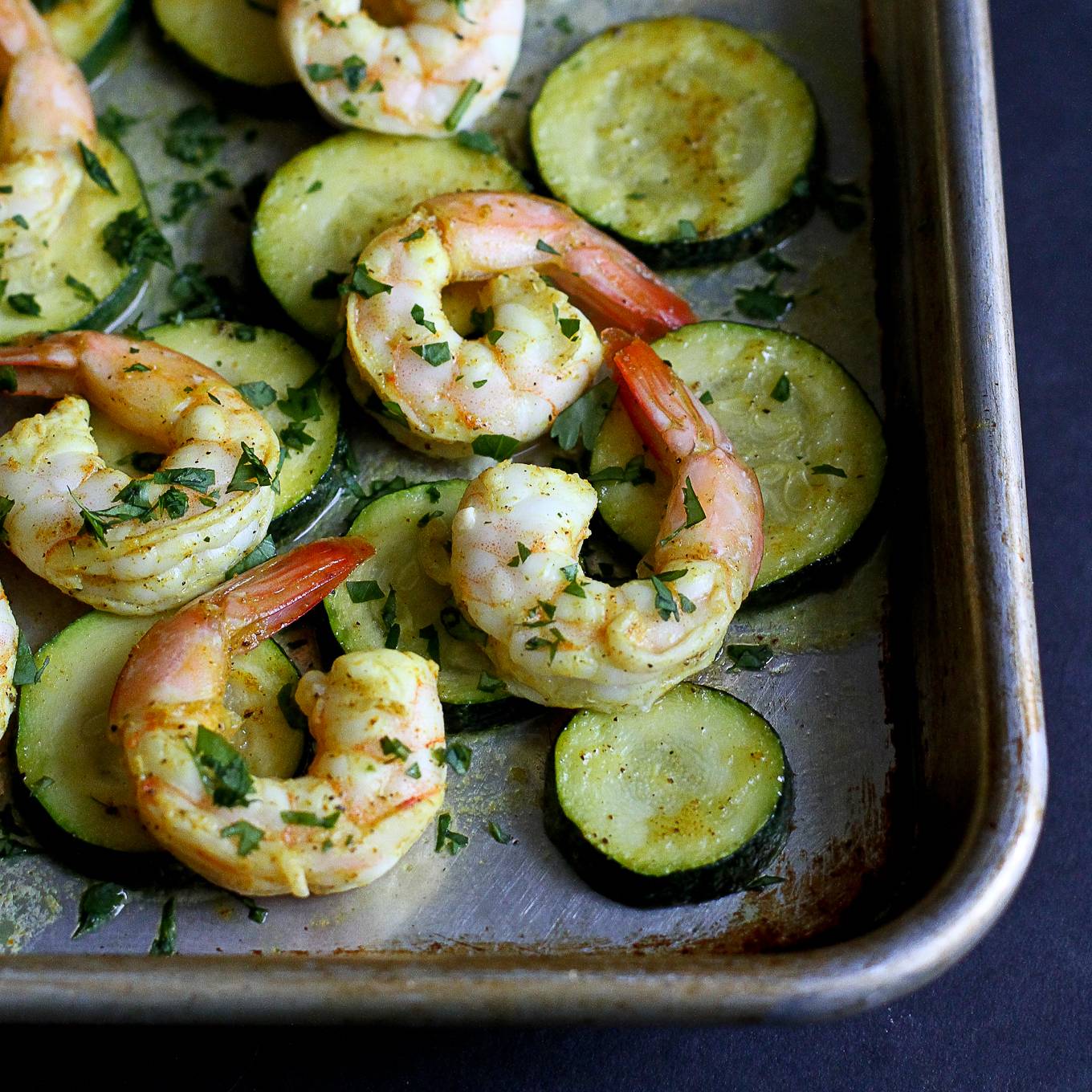 Shrimp and zucchini slices on a baking sheet.