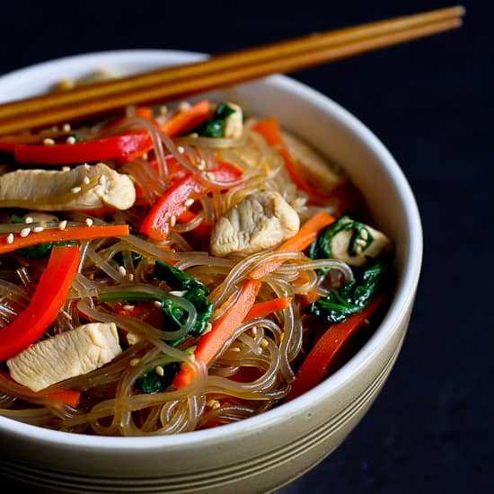 Korean glass noodles with chicken and vegetables in a bowl.