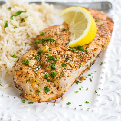 Cooked pork chops and rice on a white plate.