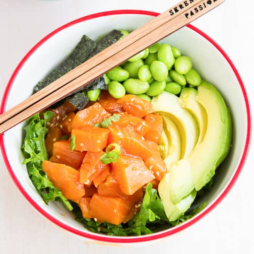 Salmon poke bowl with edamame and a variety of vegetables.
