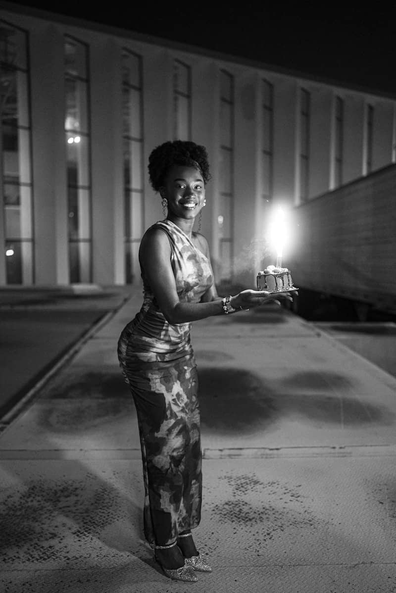 Woman holding a small cake with a lit candle