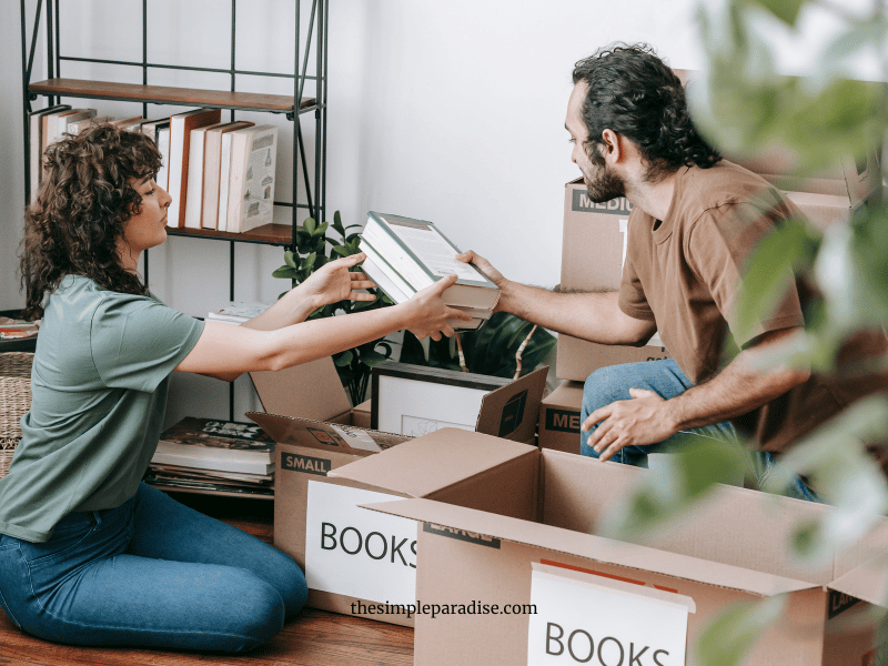 man and woman decluttering boxes on the floor