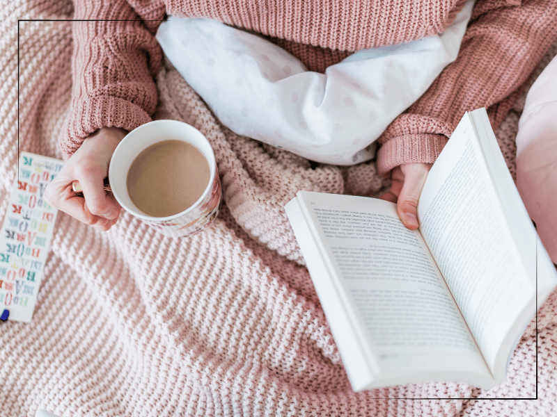 Woman holding a book and coffee