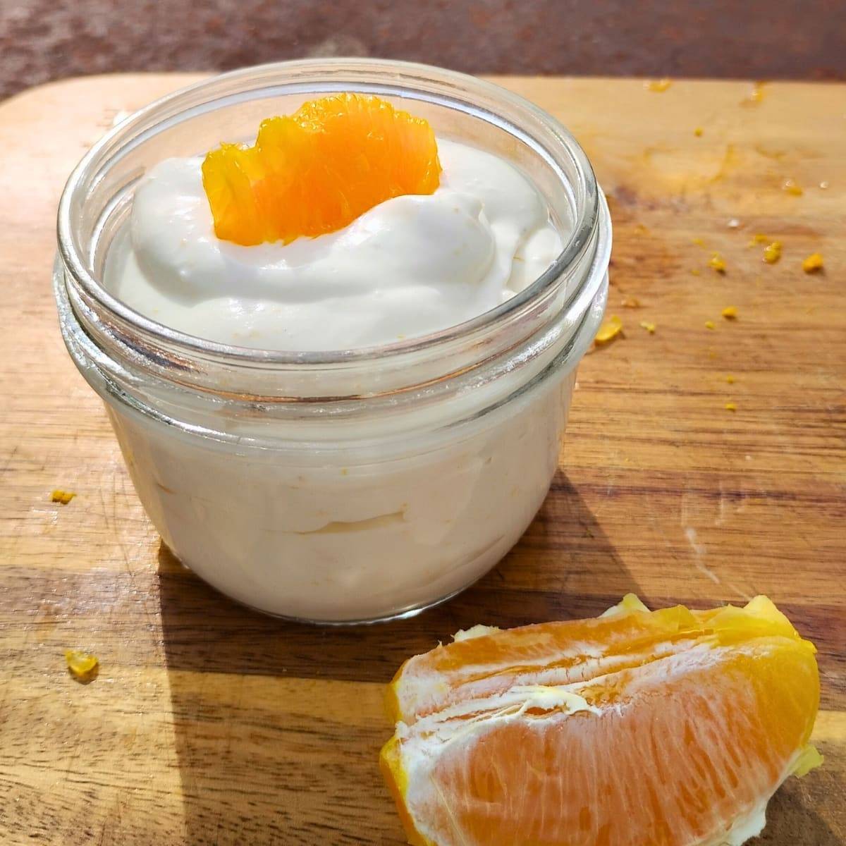 a jar full of quark cheese mousse with orange slices
