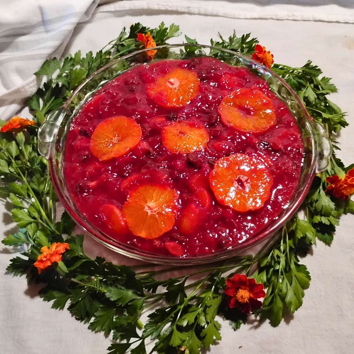 photo of a pie plate full of healthy cranberry orange sauce with parsley decoration.