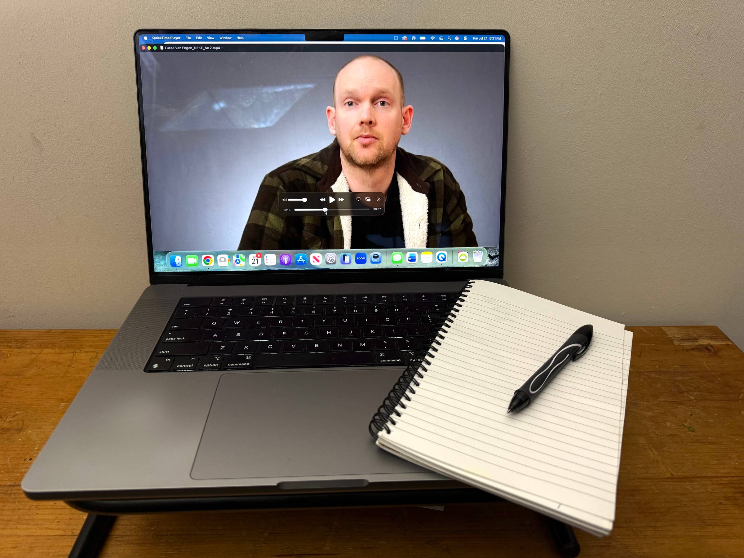 A laptop playing an old self-tape beside an open notebook and pen, ready for notes on growth and improvement as an actor.